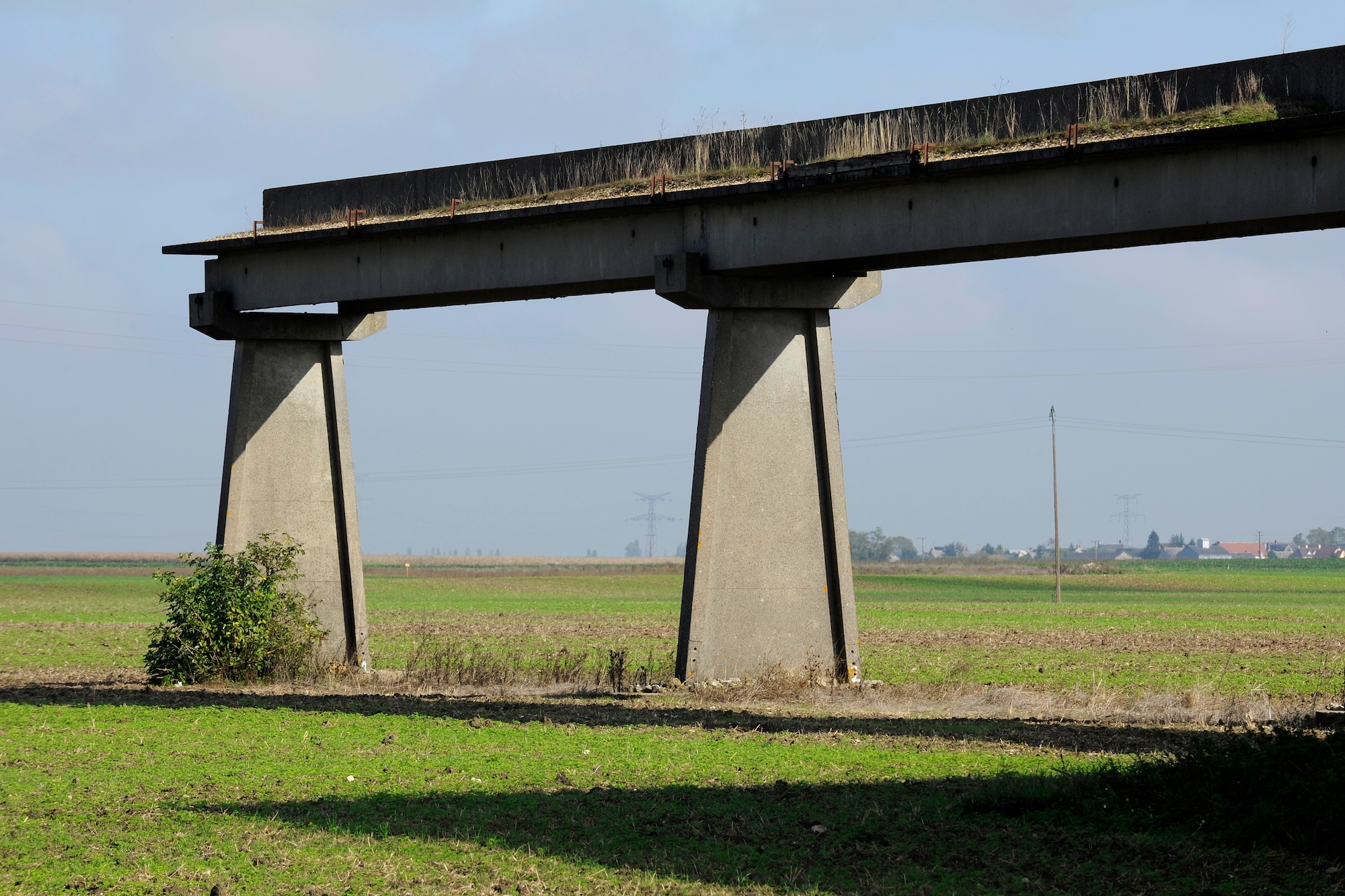 abandoned, half-finished hovertrain rail in a rural field in France.