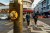 crosswalk button to turn on the green light with a background of people crossing the street;