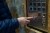 Using an Elevator: A person pressing the close door button in the elevator,