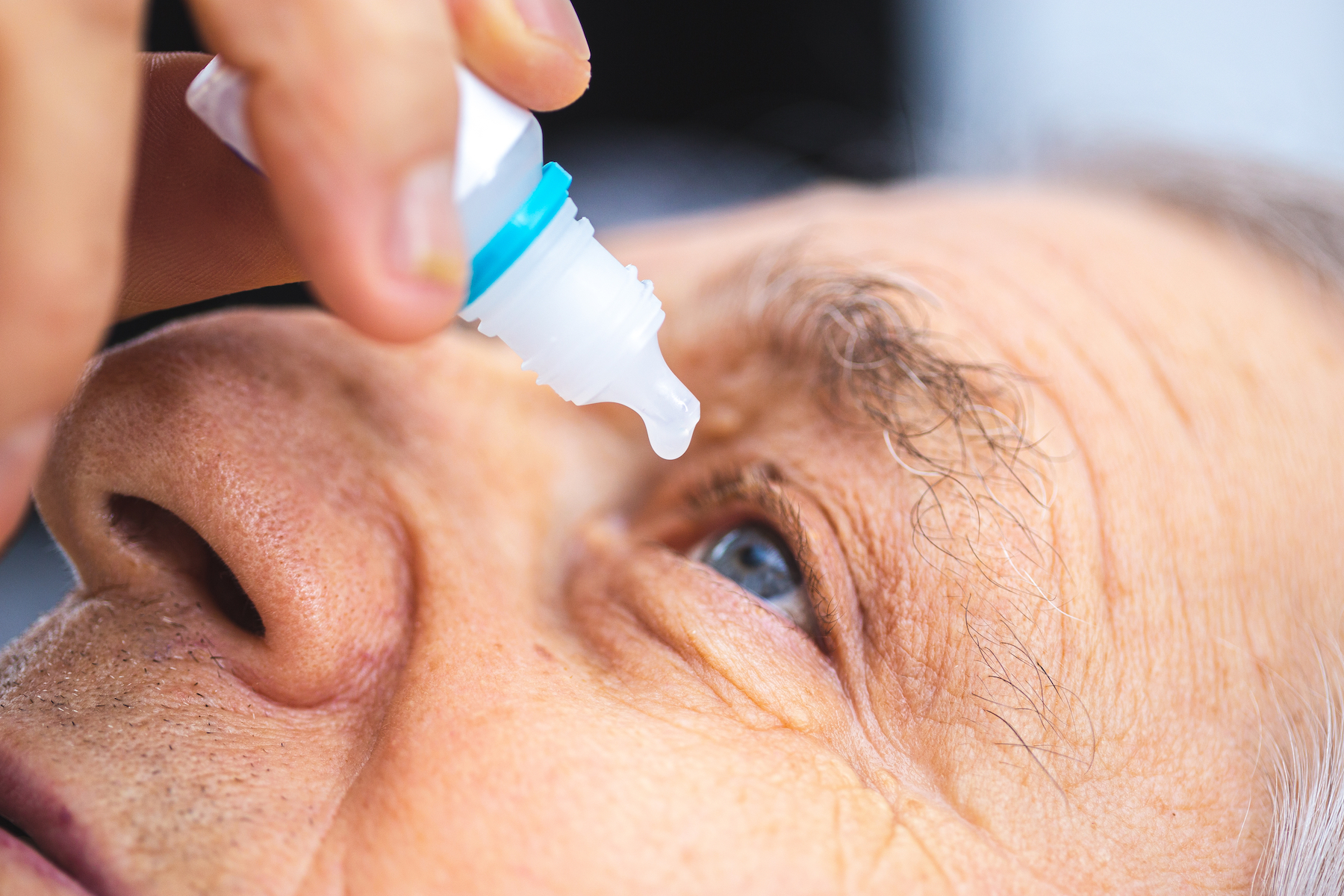 Elderly person puts eye drops in the eye. Senior man putting eye drop ; Shutterstock ID 1601745634; purchase_order: PopSci; job: ; client: ; other: