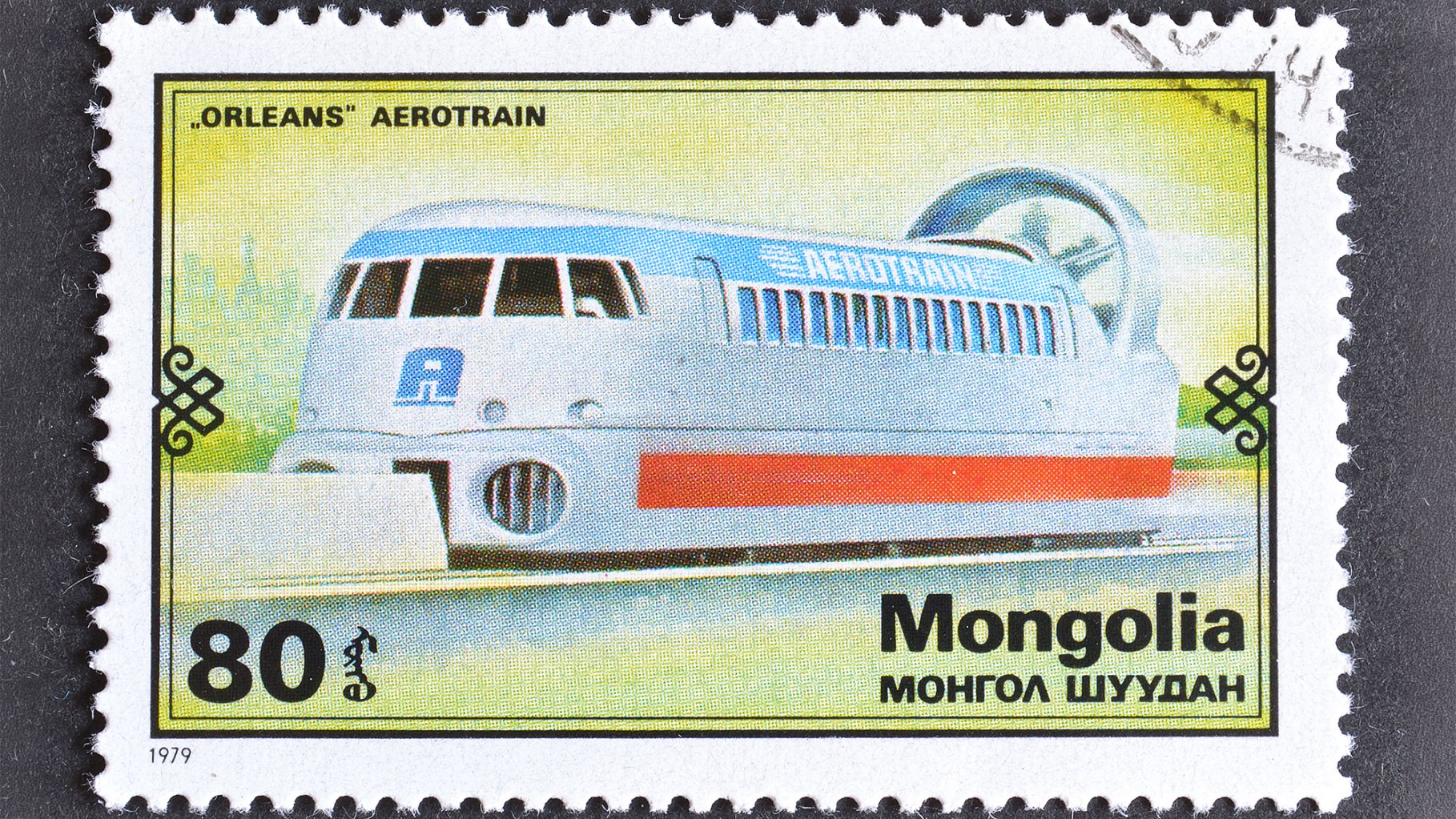 1979 postage stamp showing a futuristic hovertrain along a rail with a fan on the end on a yellowish background.