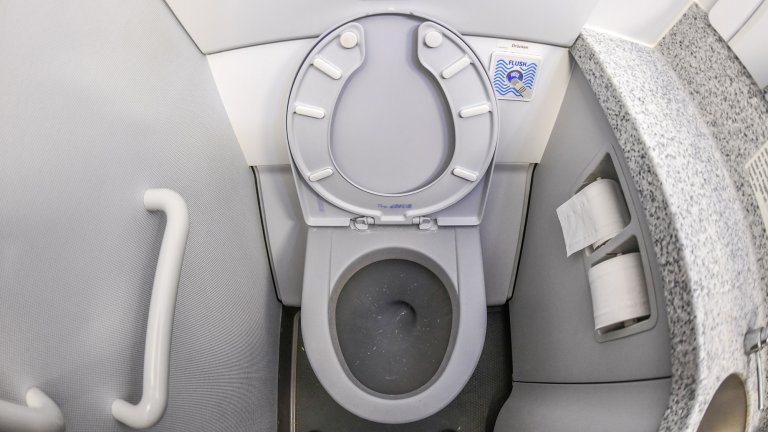 Close up of an airplane toilet with the lid open.