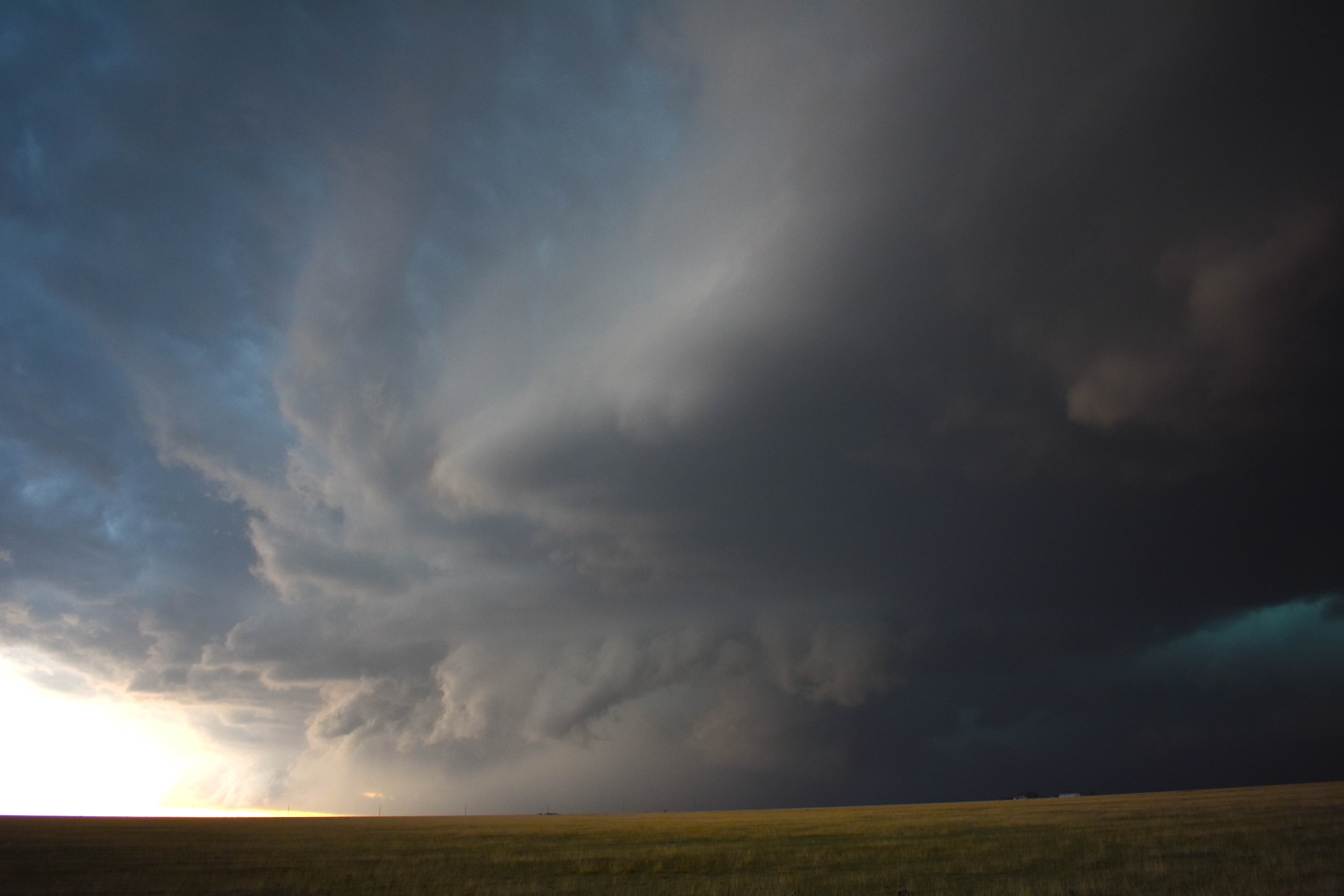 Storm clouds start to form over a rural plain.