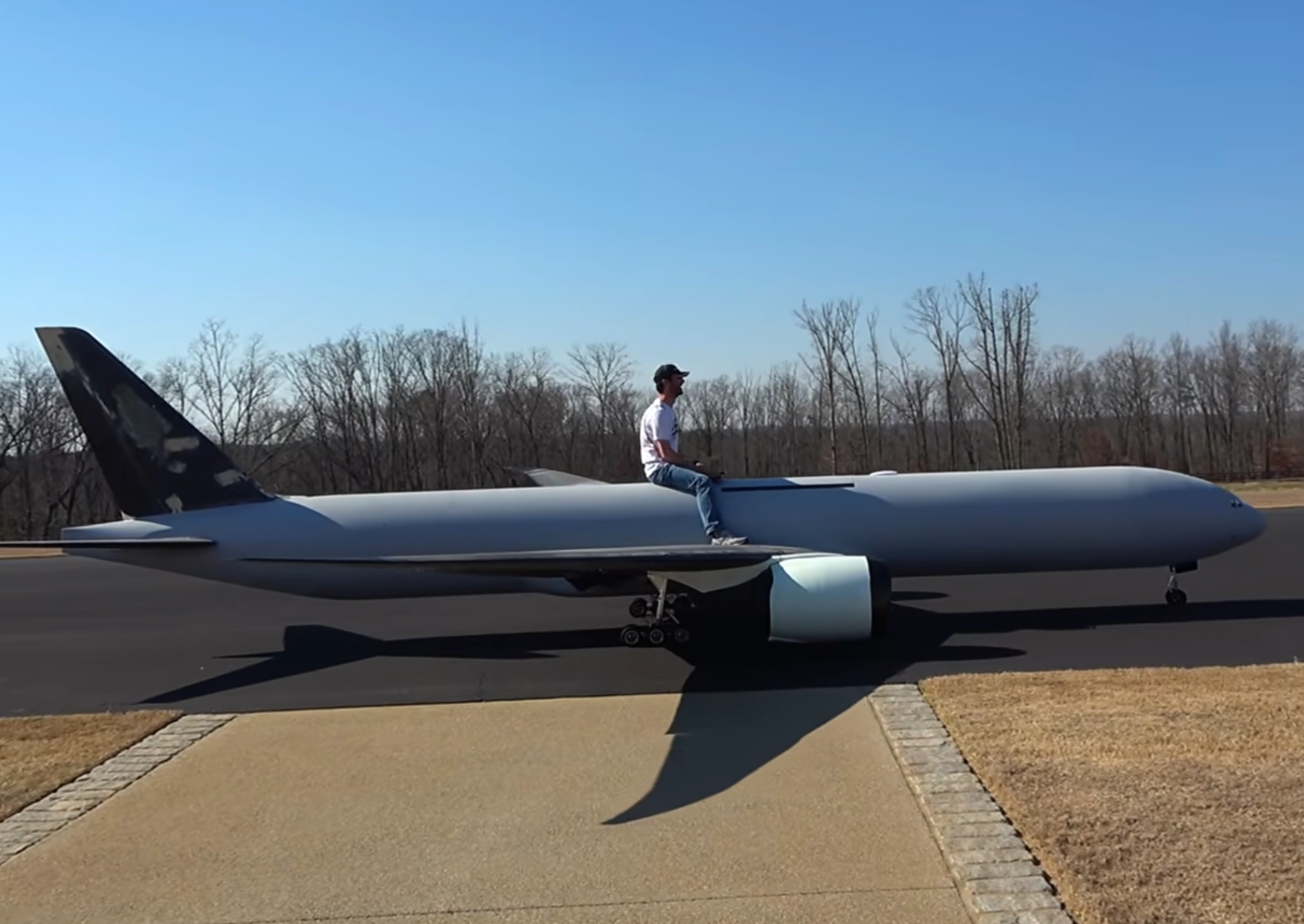 a man sitting on a large remote-controlled plane