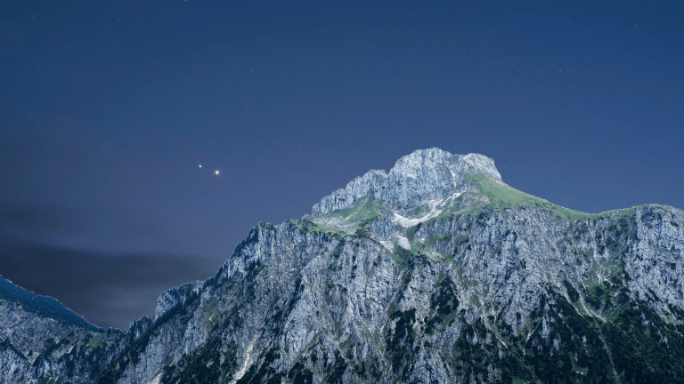 two shiny planets next to a snowy mountain
