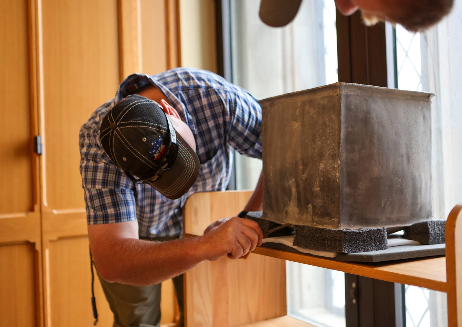 a man opening a square time capsule