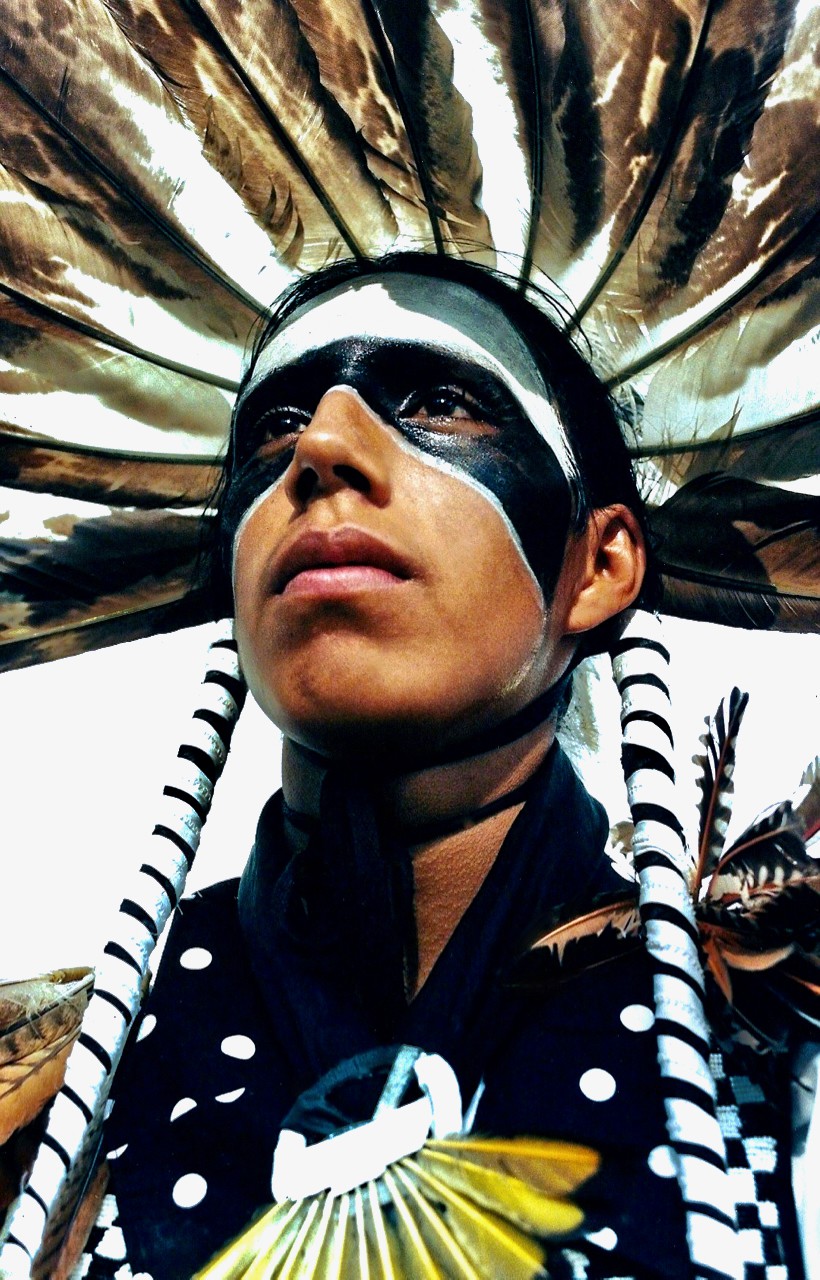 a native american in face makeup and traditional garb