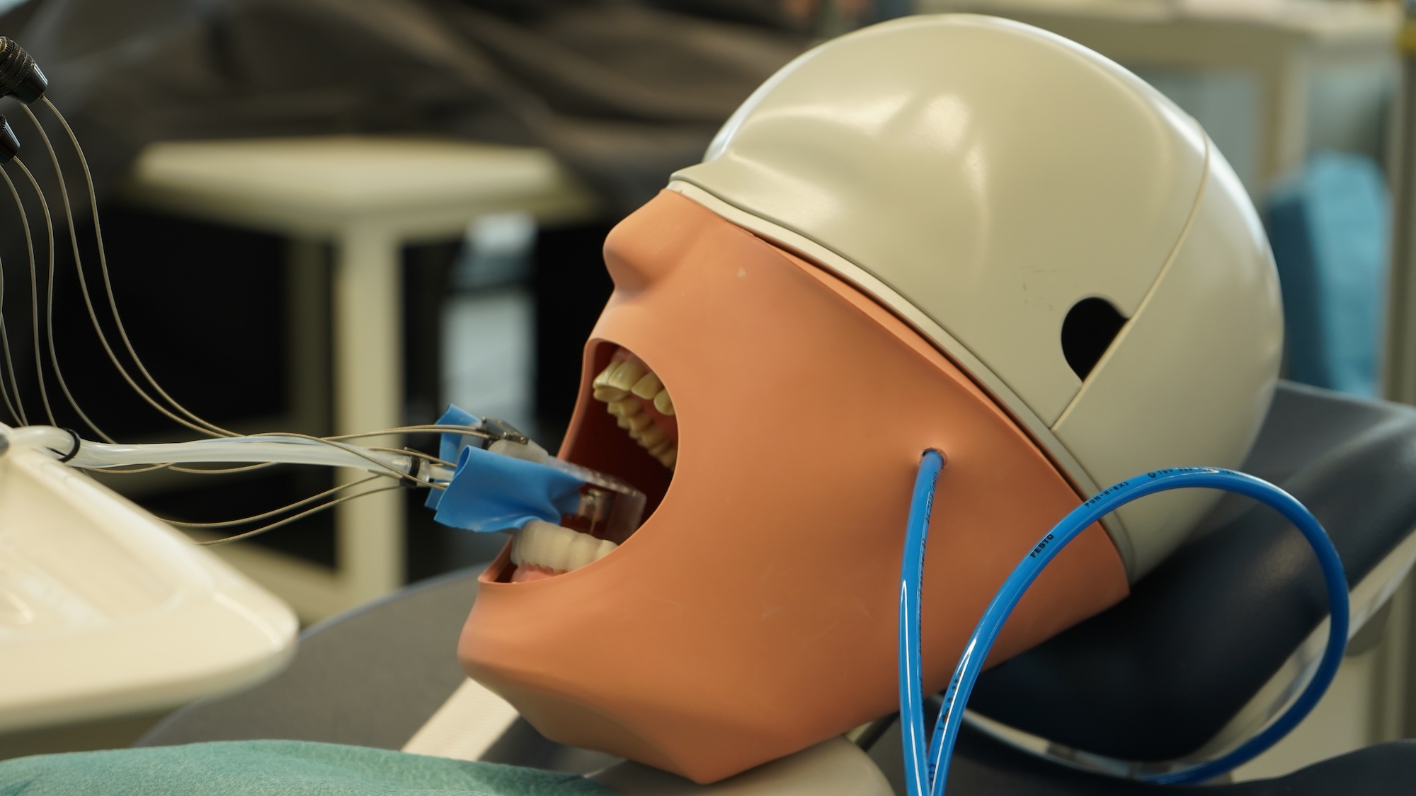 Dummy head with robot drill inserted in its mouth
