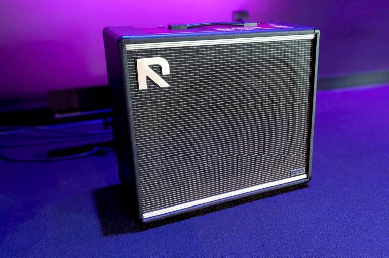 The Positive Grid REACTOR Amp Intelligence model on a stage bathed in purple and blue light.