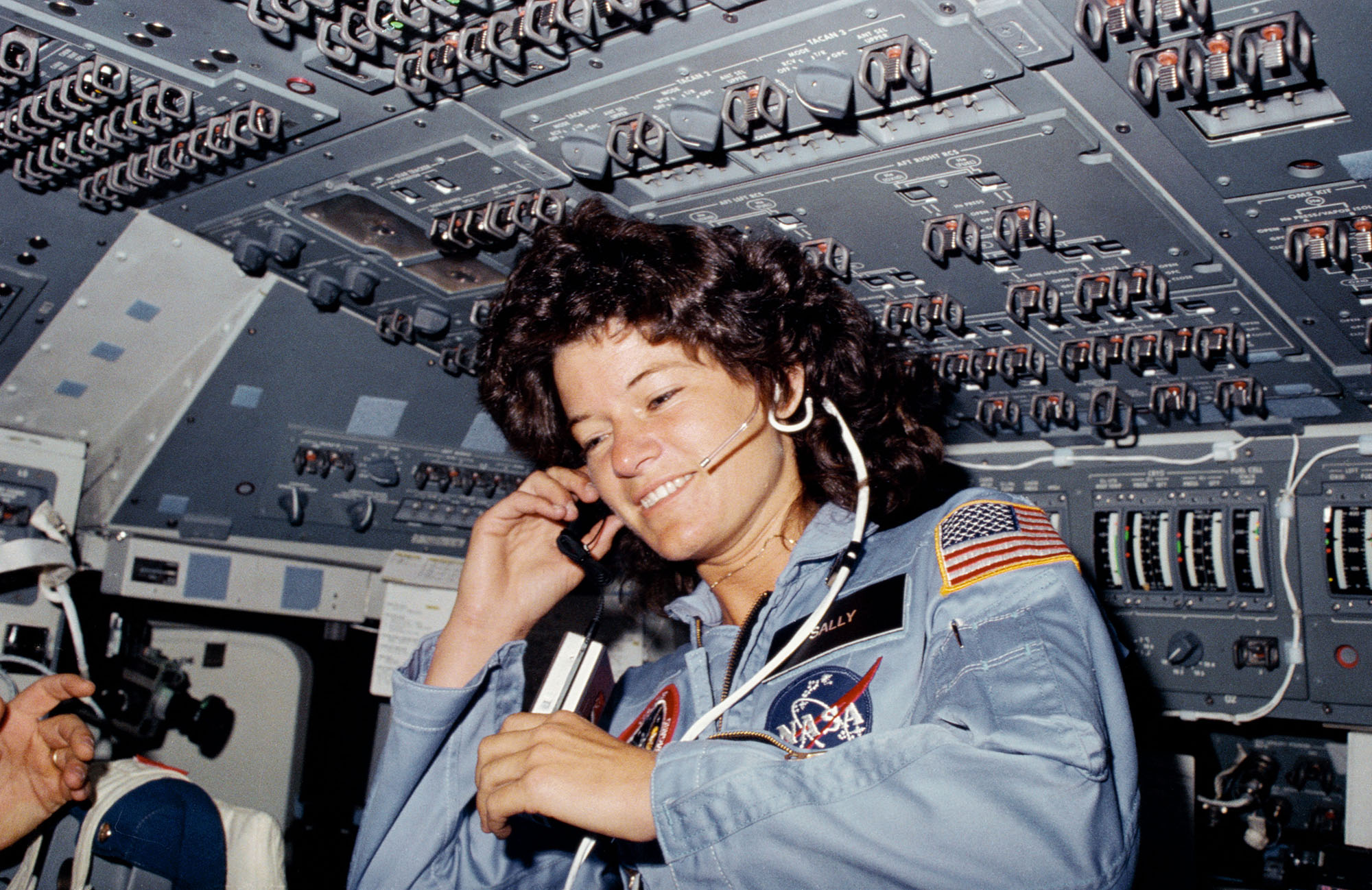 Vintage female astronaut with a headset on a flight deck.