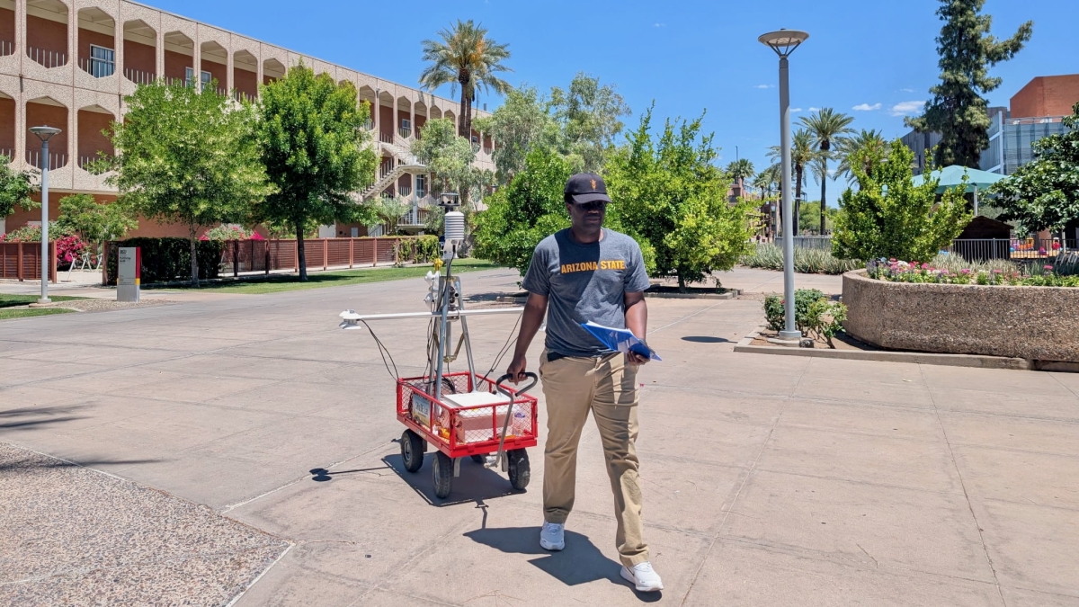 a man walks with an air temperature measuring device in a wagon