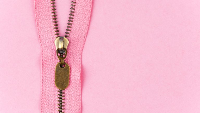 Closeup of a pink color zipper on pink background.