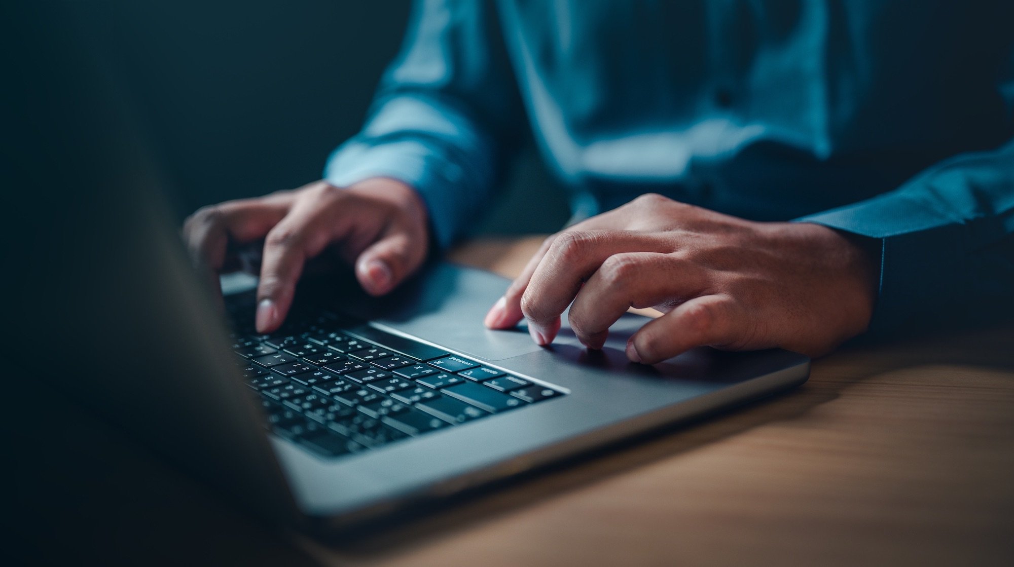 A person is typing on a laptop computer.