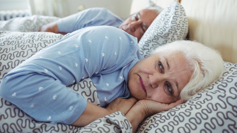 Senior woman awake on bed