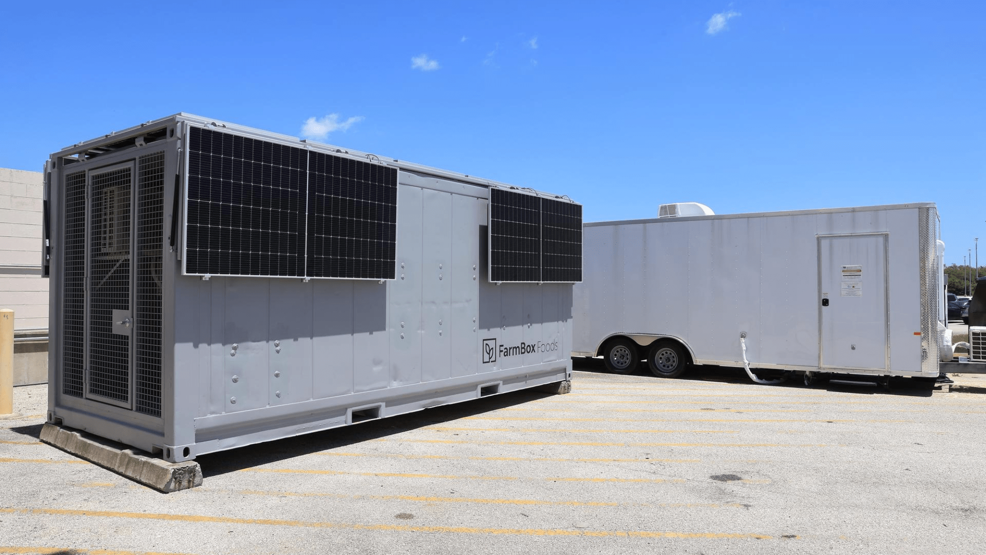 a gray trailer sits in a parking lot