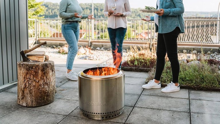 People standing on a patio near a solo stove.