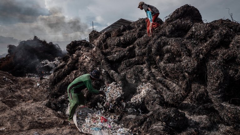 Workers prepare to burn plastic waste at a import plastic waste dump in