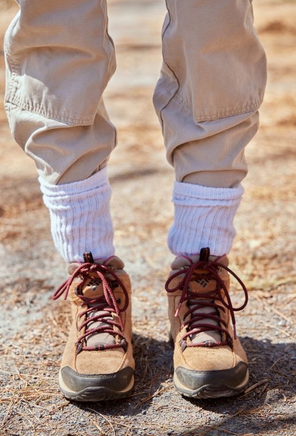 a pair of khaki pants tucked into high white socks