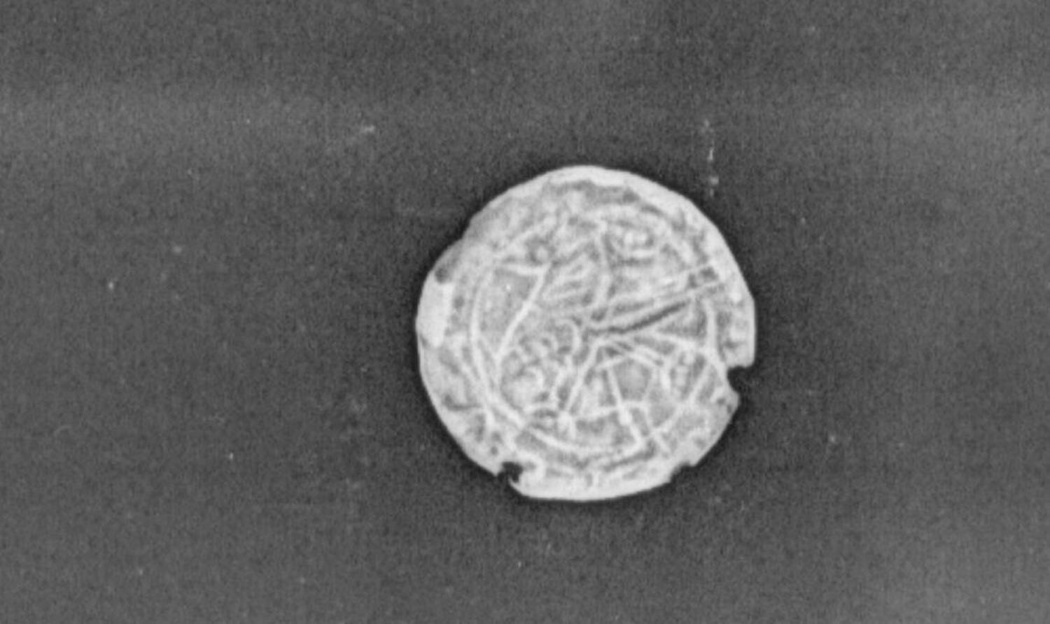 X-ray image of Viking coin face depicting outline of griffin design