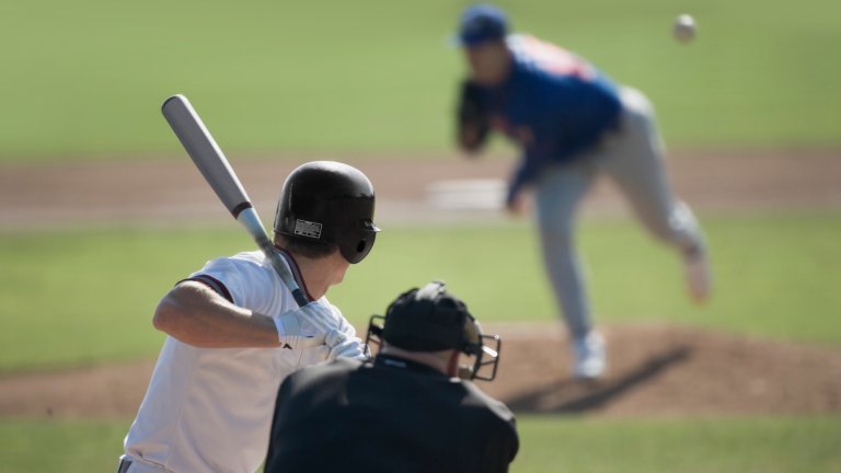 Baseball batter readying as pitcher throws ball at him