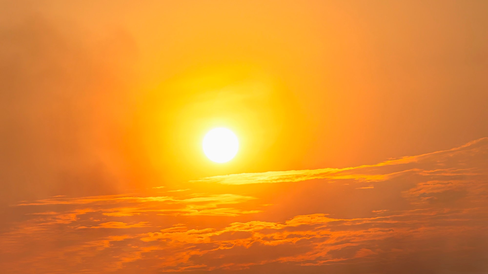 Sun in the sky covered by orange hue denoting extreme heat