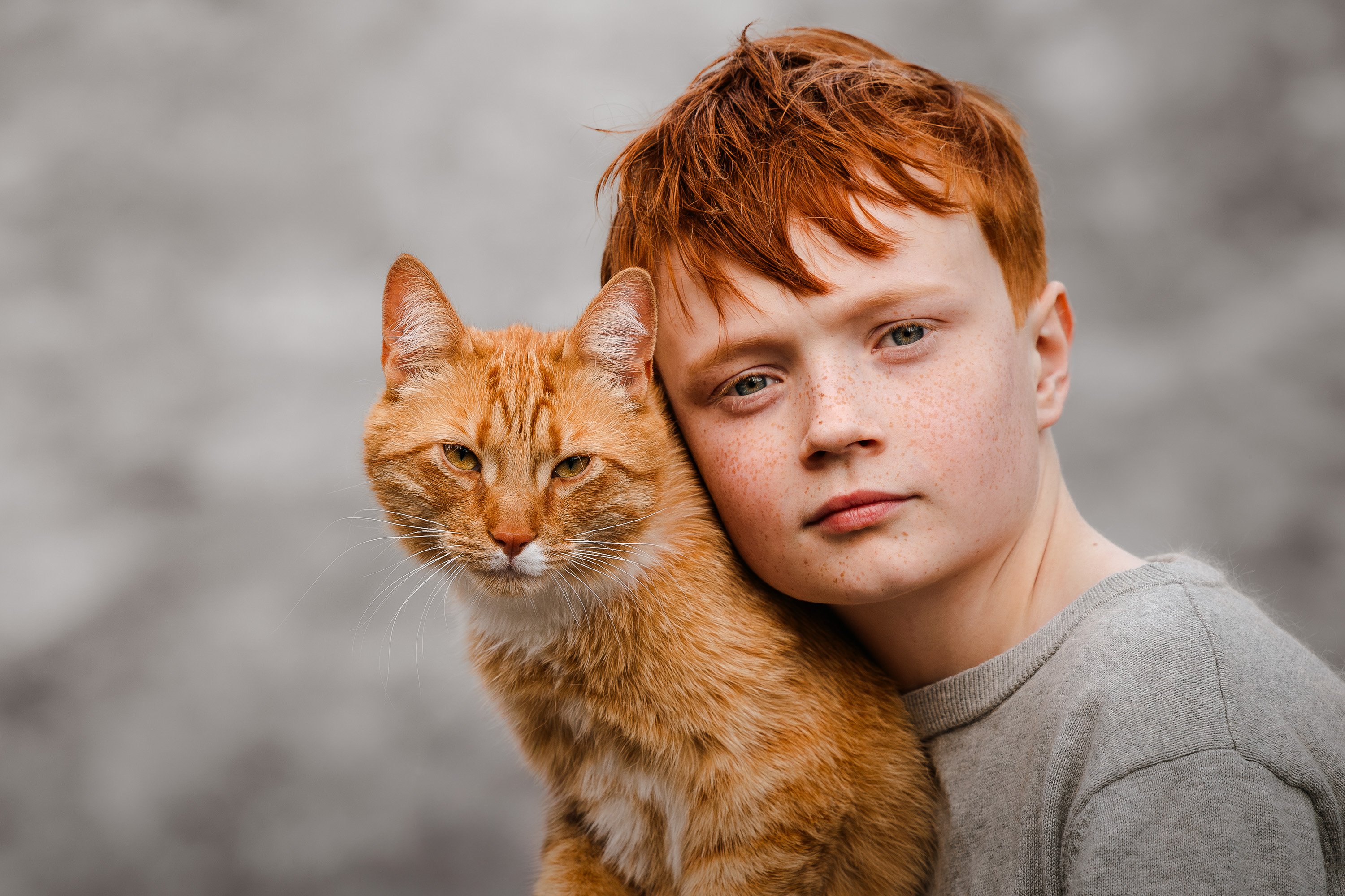 a red-haired child with orange cat