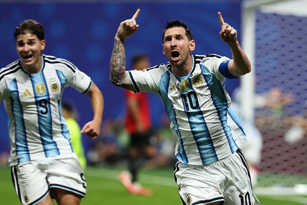 Lionel Messi celebrates goal with his fingers pointed in the air.