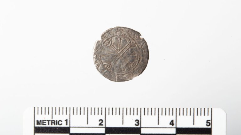Old Viking silver coin minted by King Magnus Barefoot with ruler for scale
