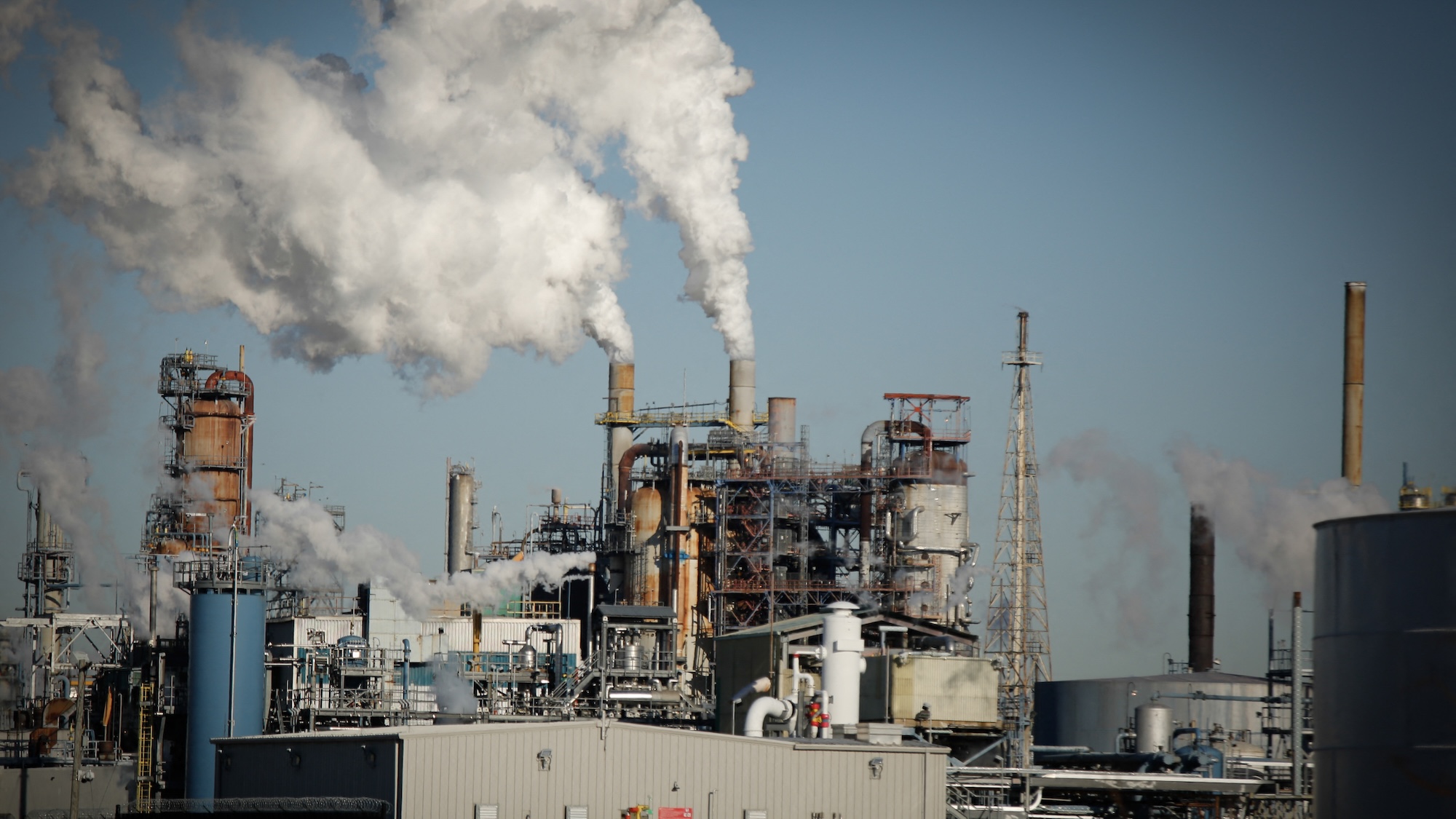 Smoke emanates from smokestacks at the Phillips 66 Bayway Refinery in Linden, New Jersey, on March 18, 2026. Oil prices surged Wednesday following a strike on a major Iranian gas facility as the Federal Reserve raised its inflation forecast while holding interest rates steady. (Photo by kena betancur / AFP)