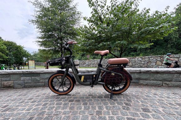 The Segway MUXI cargo e-bike sitting on cobblestones beside the bike path at the entrance to Theodore Roosevelt Island.