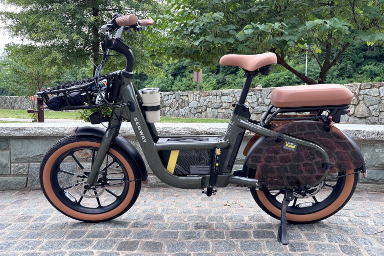 A closer view of the Segway MUXI cargo e-bike sitting on cobblestones beside the bike path at the entrance to Theodore Roosevelt Island.