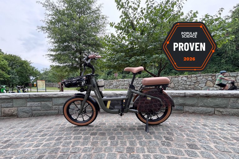 The Segway MUXI cargo e-bike sitting on cobblestones beside the Mount Vernon bike path at the entrance to Theodore Roosevelt Island. The PopSci Priven badge is shown in the top right corner.