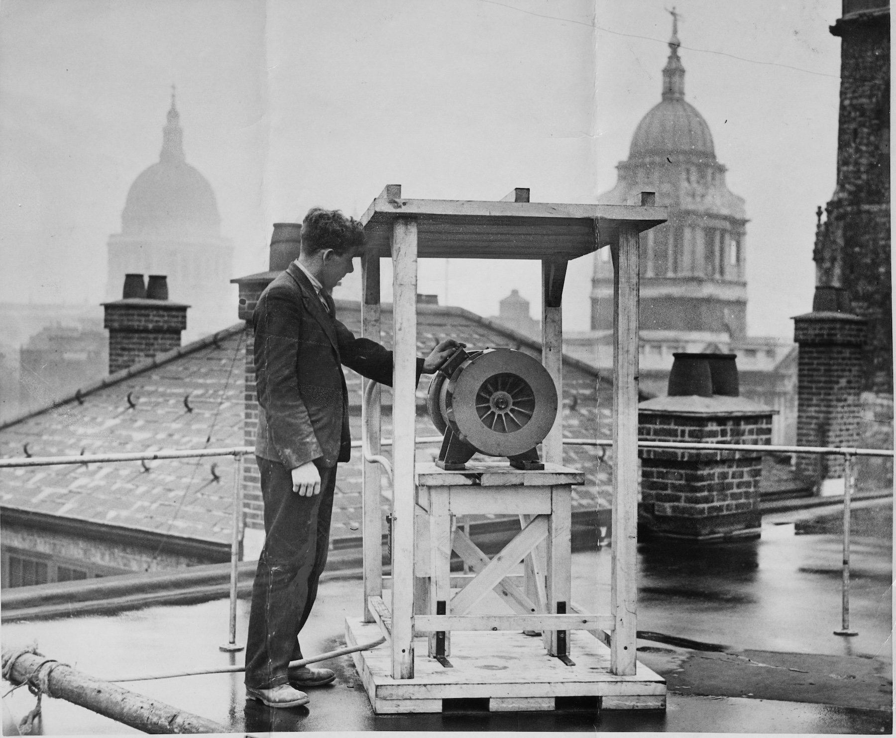 A man checks a new air raid siren on a roof within sight of the domes of the City. As war with Germany began to seem inevitable in late 1938, 100 sirens were installed and tested on the roofs of police stations all over London. (Photo by © Hulton-Deutsch Collection/CORBIS/Corbis via Getty Images)