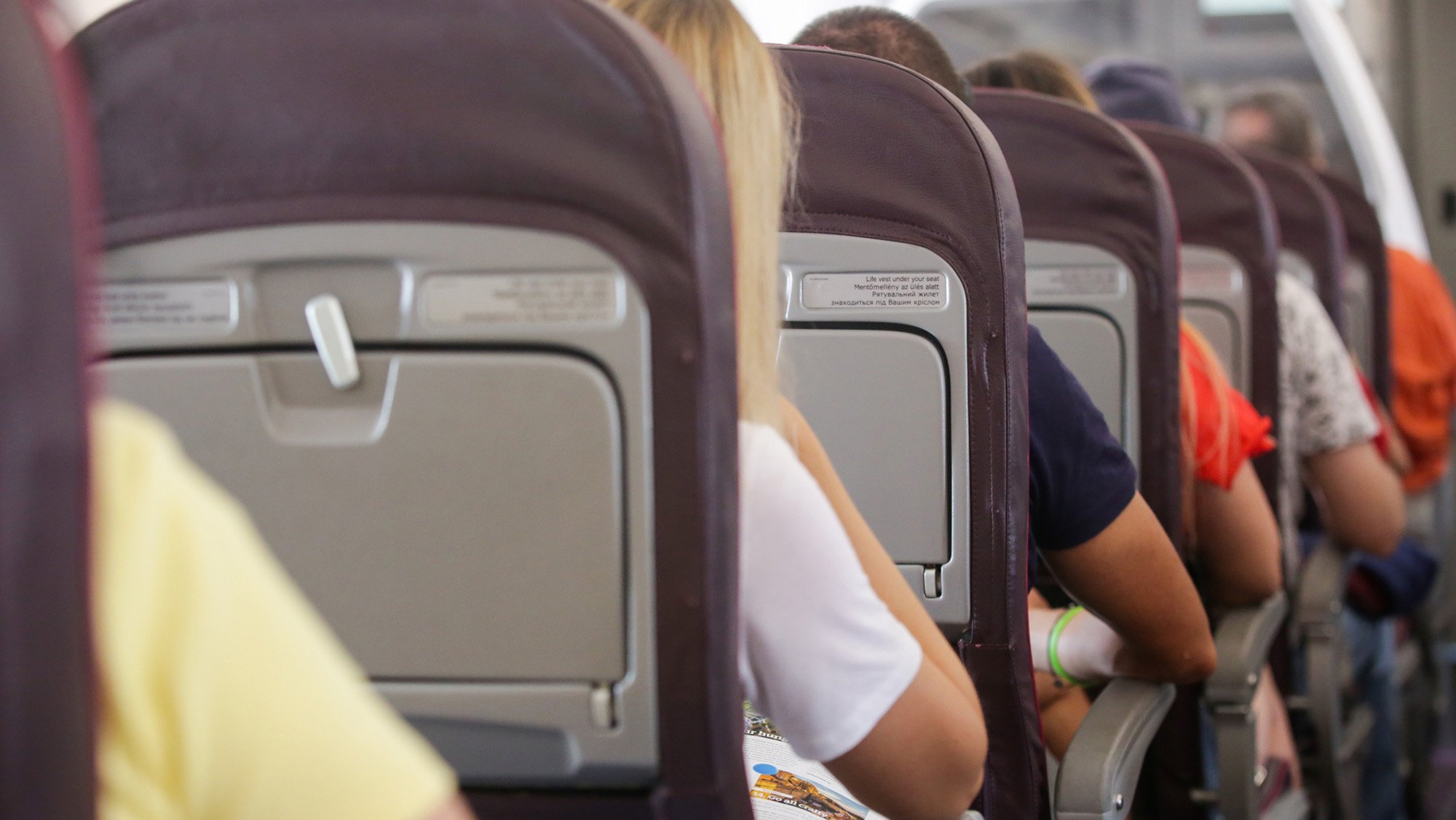people sitting in crowded airplane.