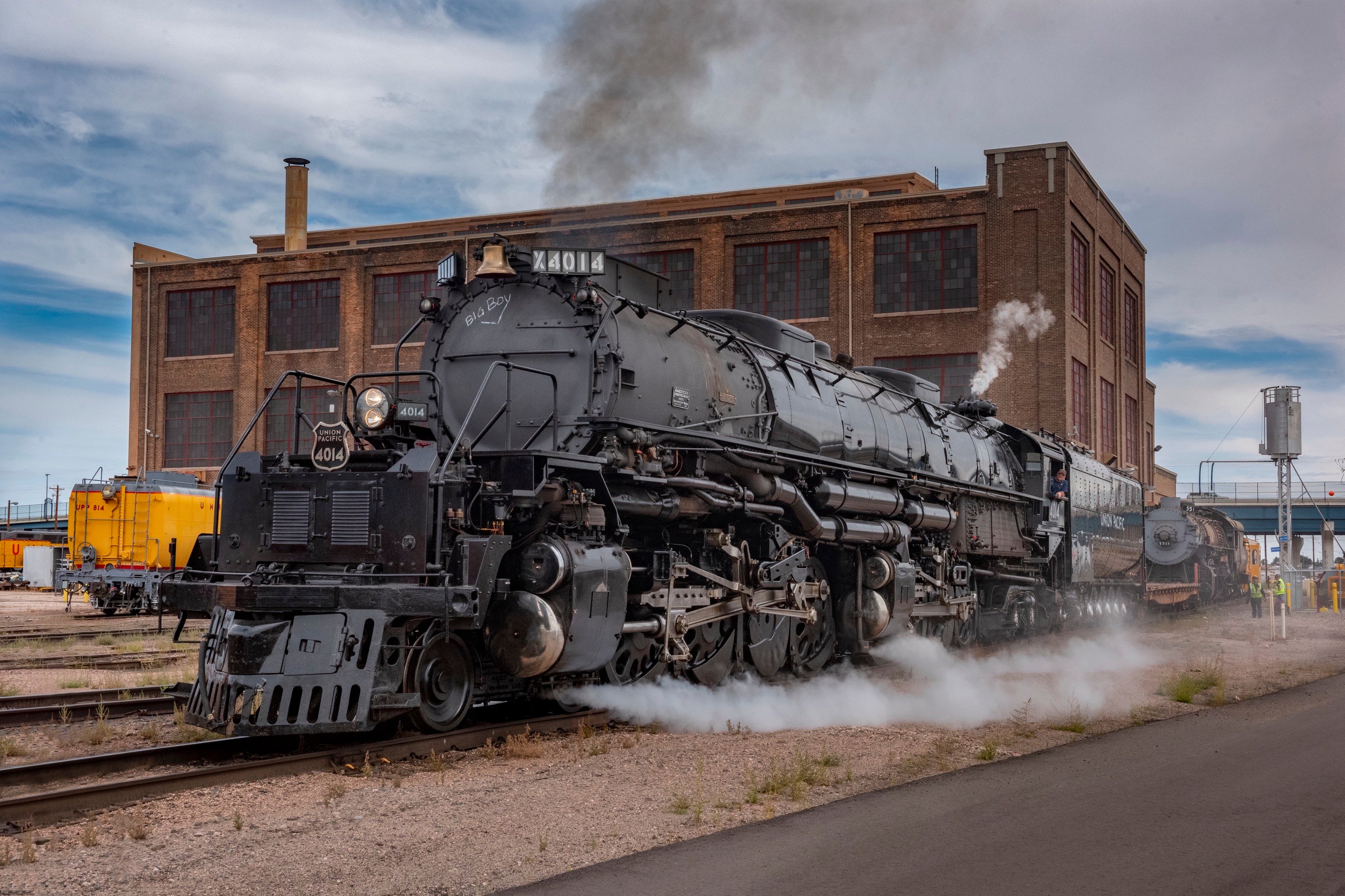 a large steam train outside of a building