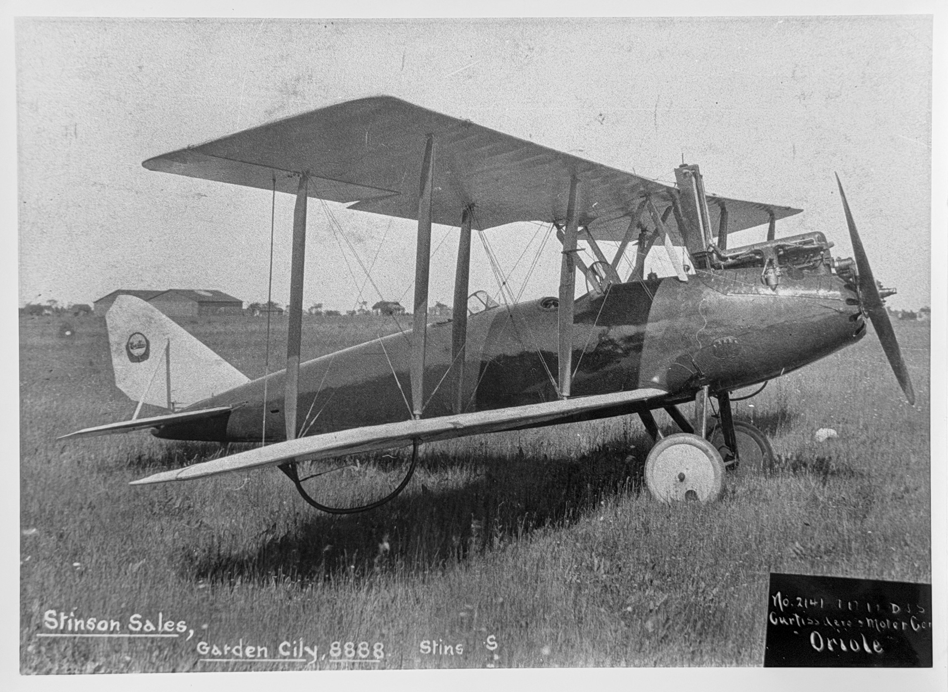 a black and white photo of a biplane in a field