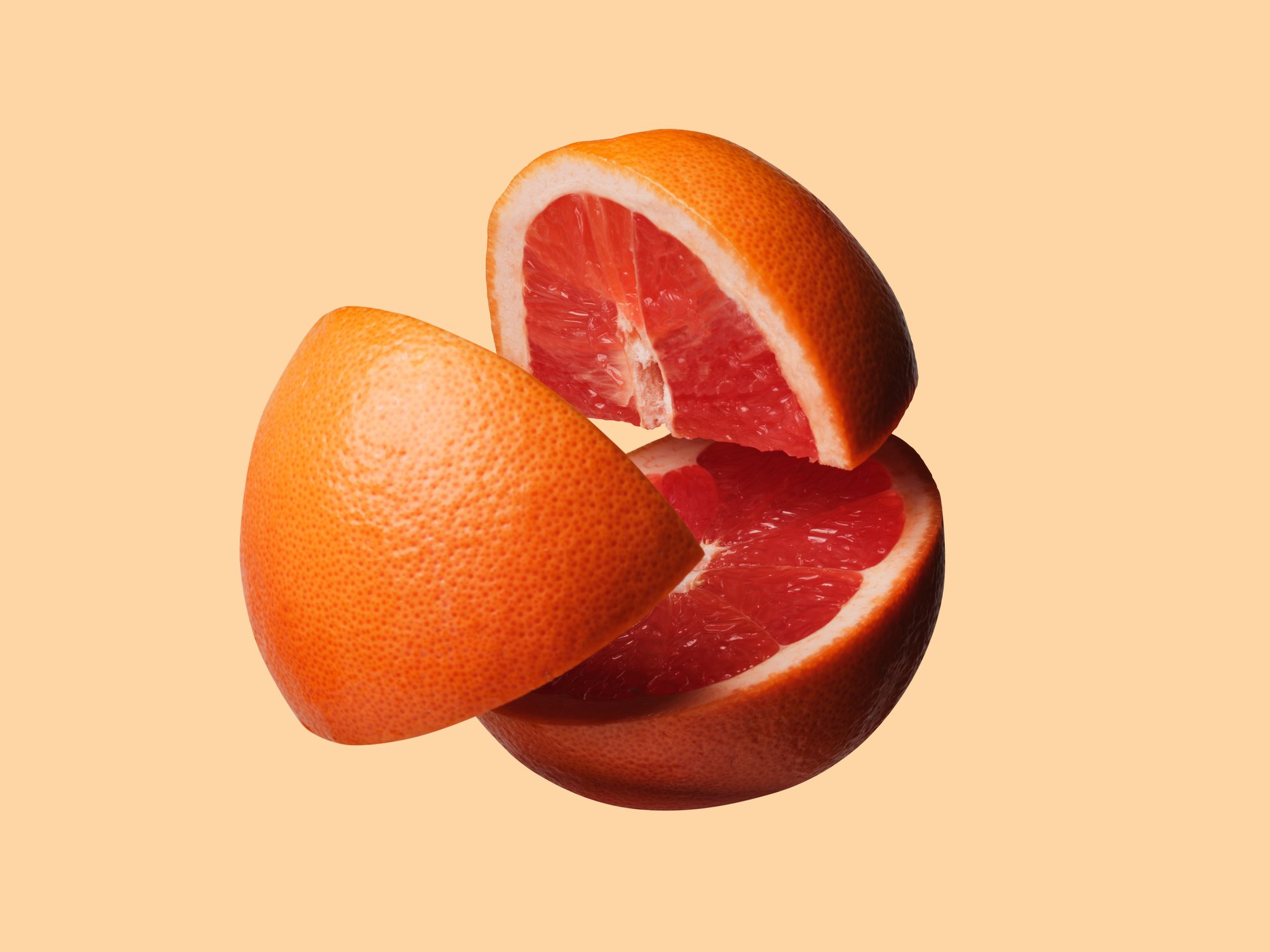 Grapefruit cut into three pieces, floating in the air