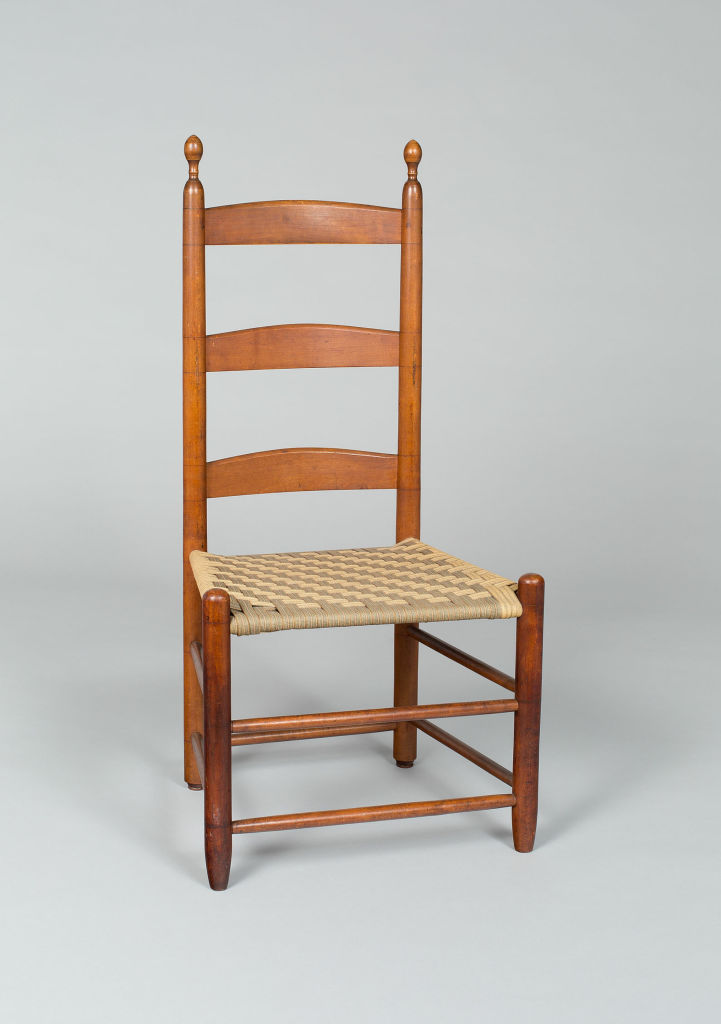 A simple wooden chair with a woven seat.