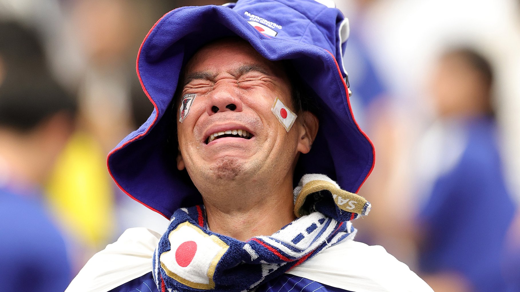 Japanese man dressed in soccer swag cries in close up after team loses.