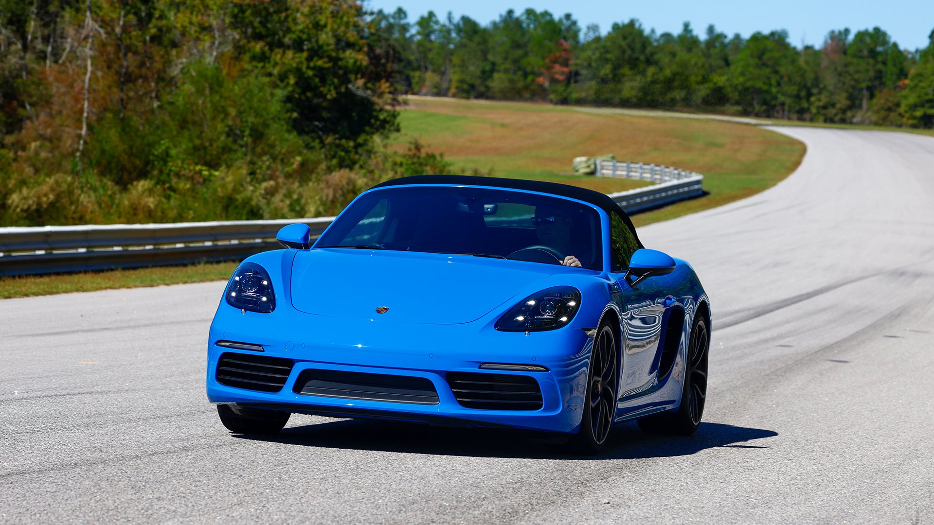 Blue sports car driving down a highway