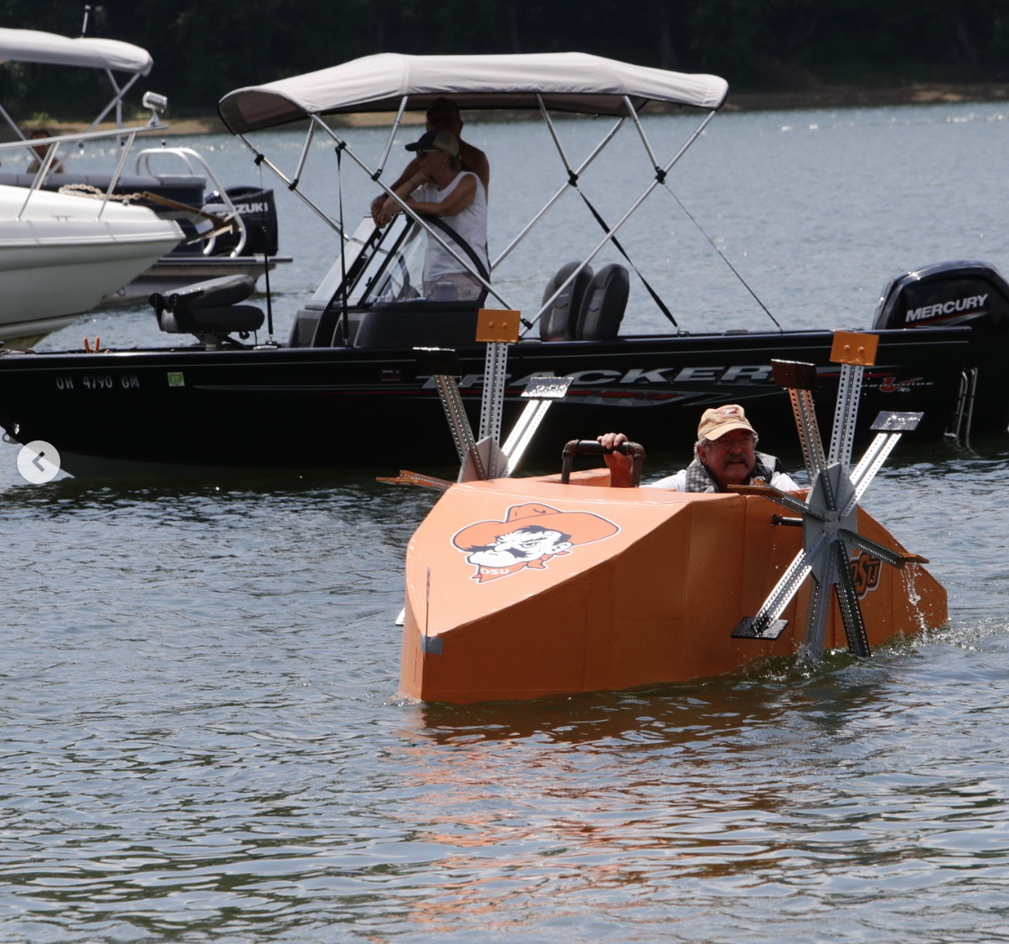 Man in cardboard boat with metal propellers