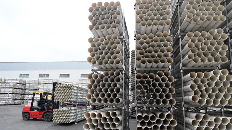 NEIJIANG, CHINA - NOVEMBER 30: A worker transfers PVC pipes at a factory of Sichuan Hongyu Hengchuang Plastic Products Co., Ltd. on November 30, 2022 in Neijiang, Sichuan Province of China. (Photo by Lan Zitao/VCG via Getty Images)