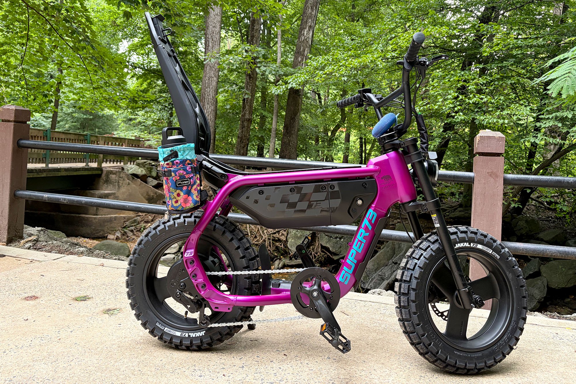 A Super73-MZT moto-style e-bike in Cullenberry shown from the side with an open compartment in a park
