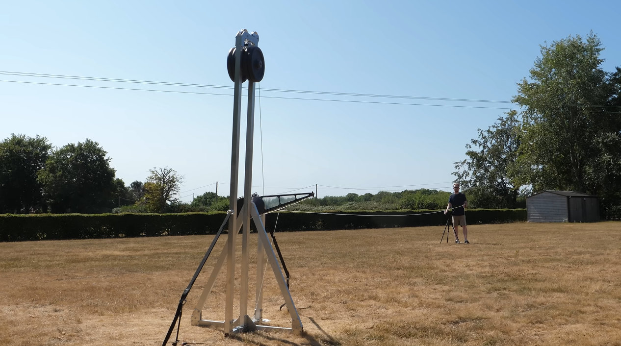 Supersonic trebuchet in backyard with man standing behind it