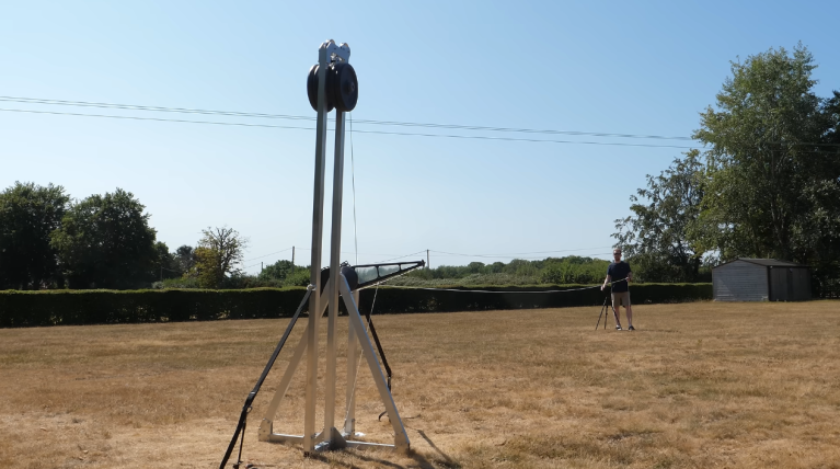 Supersonic trebuchet in backyard with man standing behind it