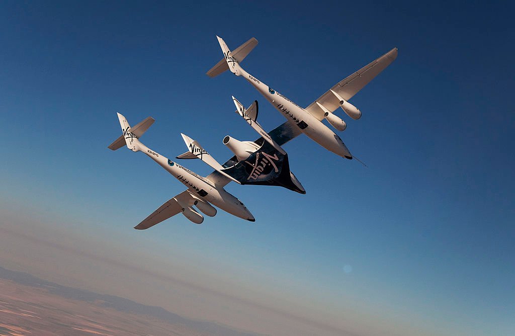 A weird looking plane with four tails flies over the desert.