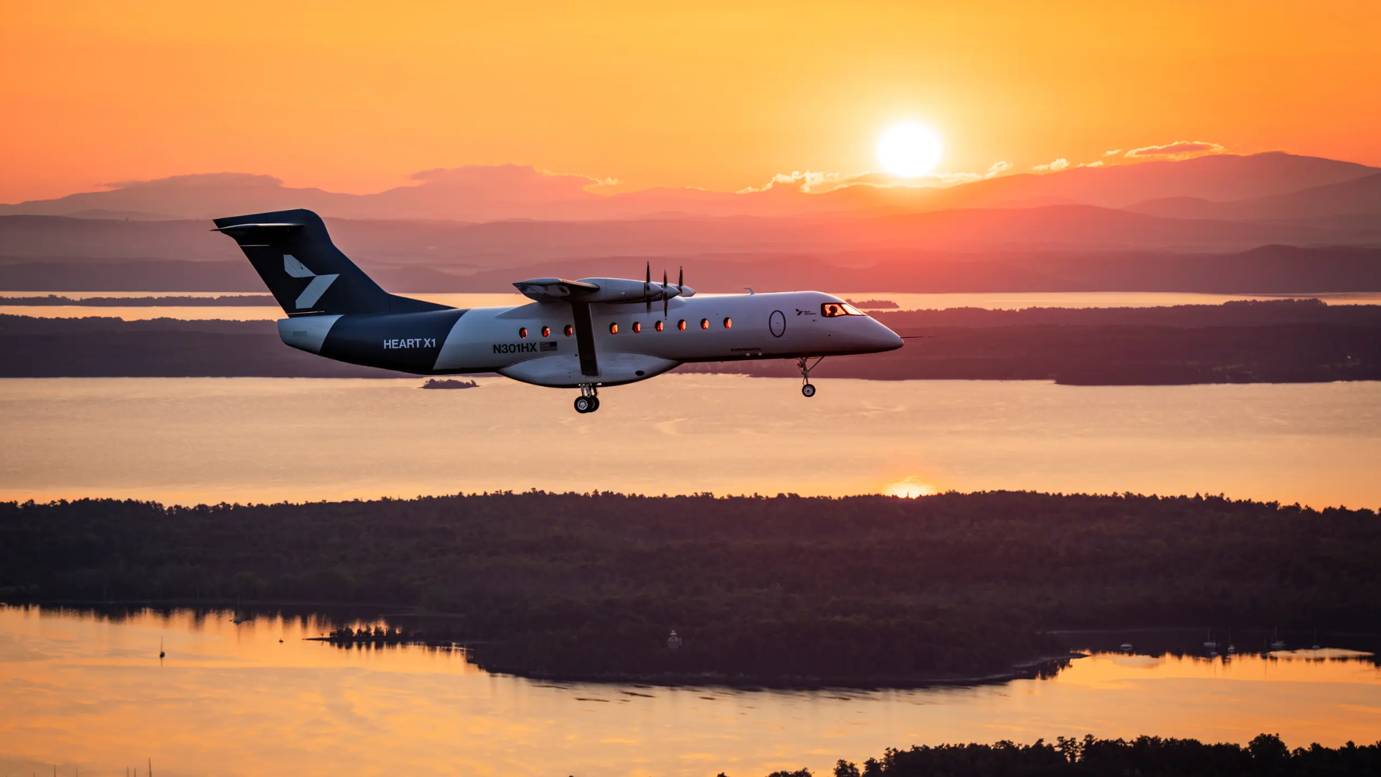 a white plane flies as the sun sets over a lake