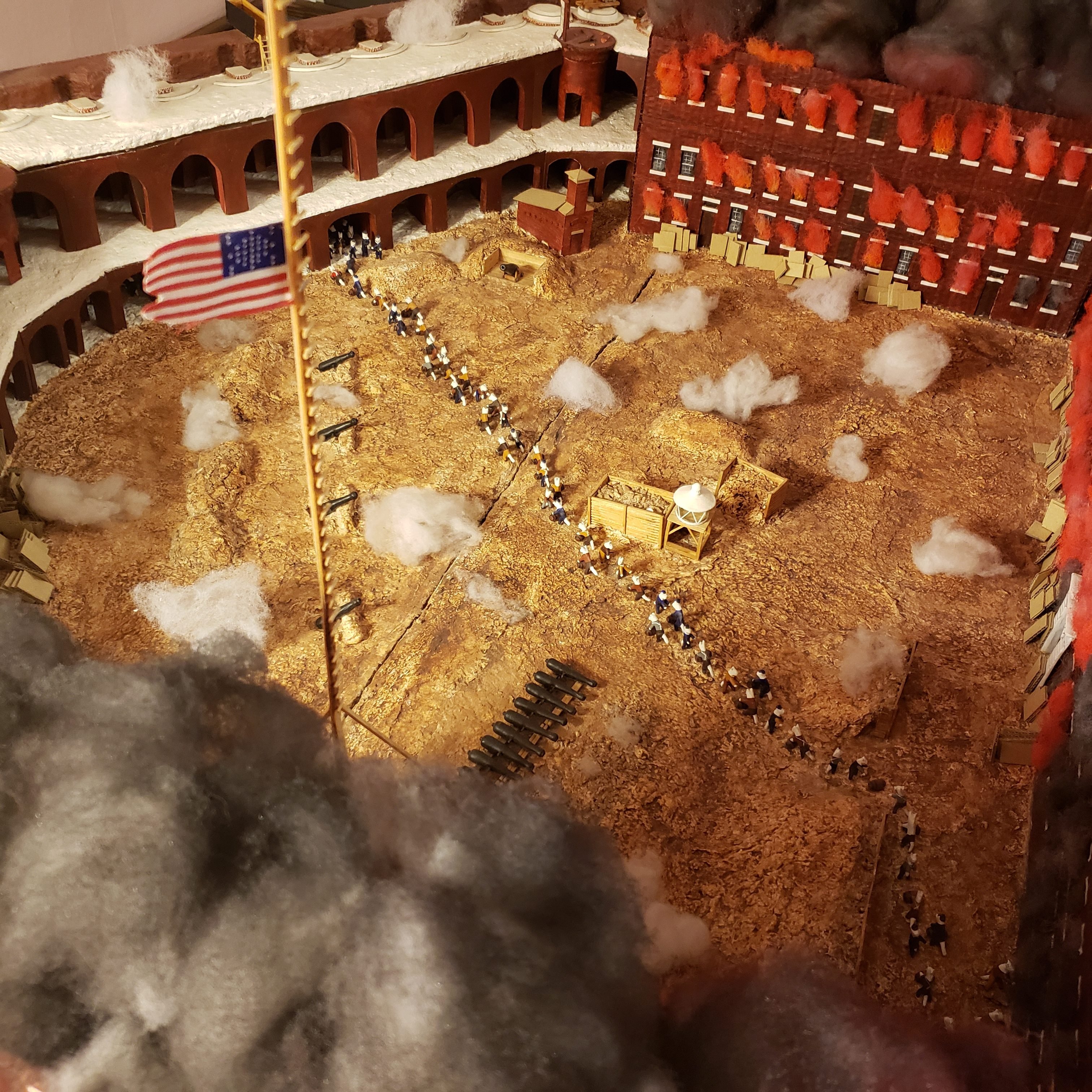 a diorama showing a military fort burning