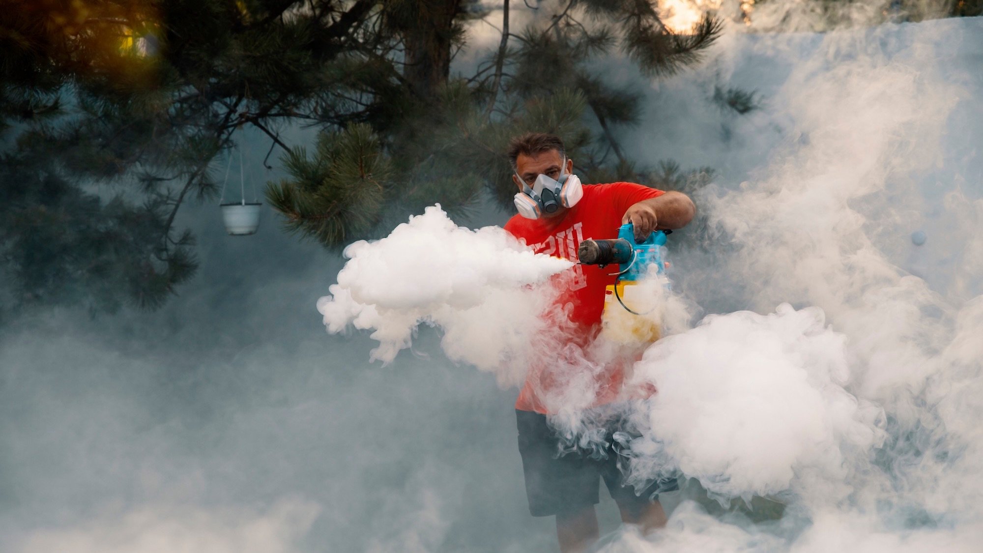 Man use fumigation machine for kill mosquito carrier of Zika virus and dengue fever prevention on Summer season outdoors
