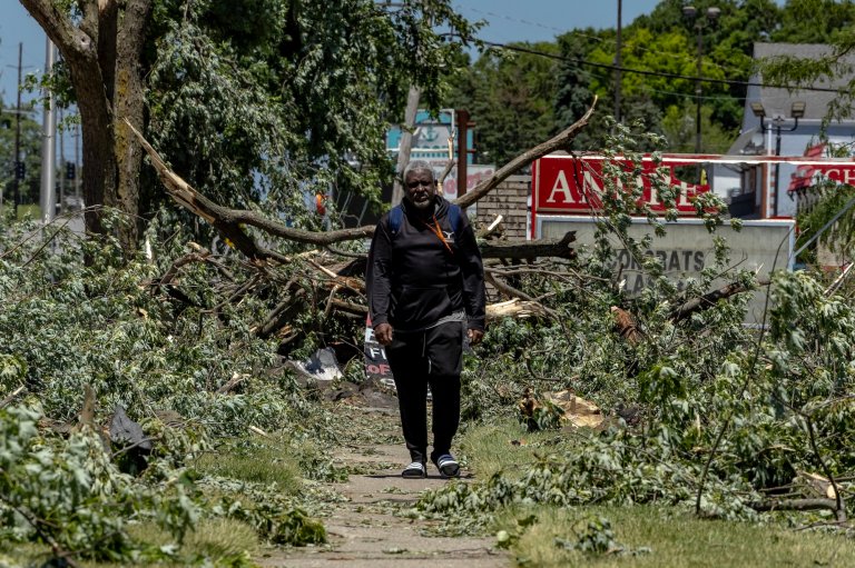 MERRILLVILLE, INDIANA - JUNE 12: A man walks through debris in front of Andrean High School after it was damaged by tornado winds on June 12, 2026 in Merrillville, Indiana. A tornado system passed through the area the previous night, causing wide spread damage to homes and businesses. (